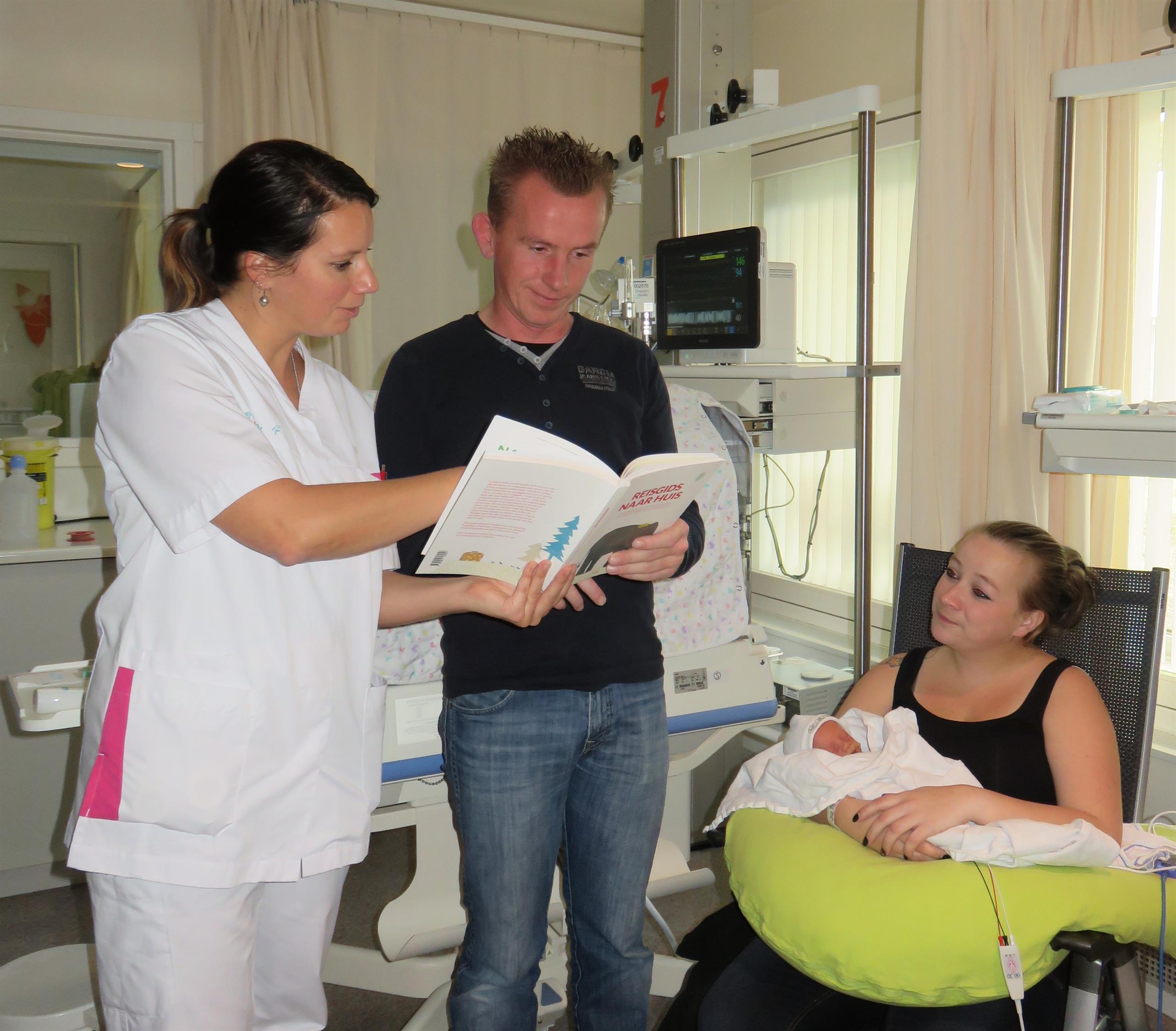Neonatologie verpleegkundige Joyce legt vader Jeffrey uit wat hij zoal kan lezen in het boek