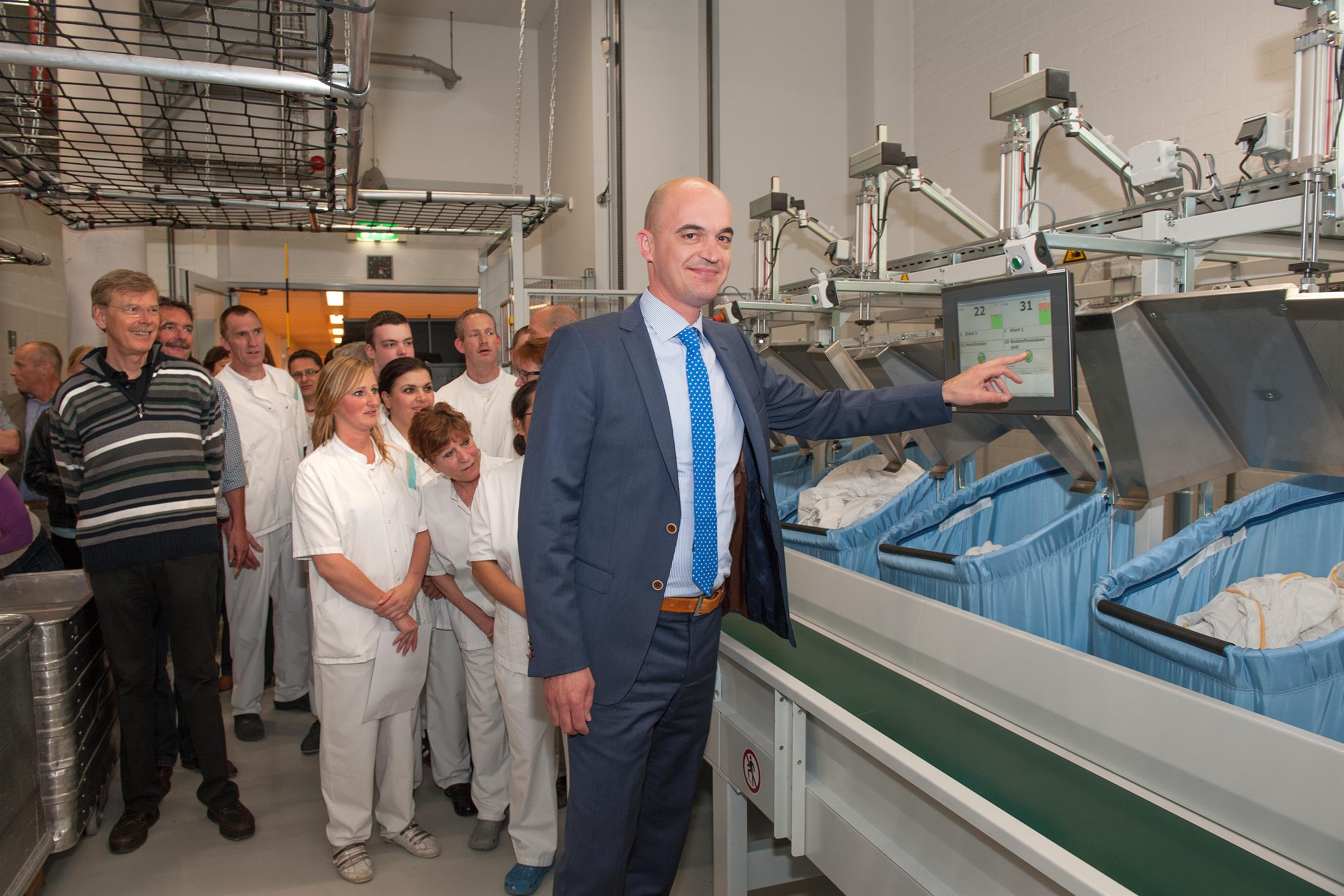 Kees Wolse, lid Raad van Bestuur, opende de nieuwe wasserij van het Elkerliek ziekenhuis door de ‘wasstraat’ in werking te zetten. 